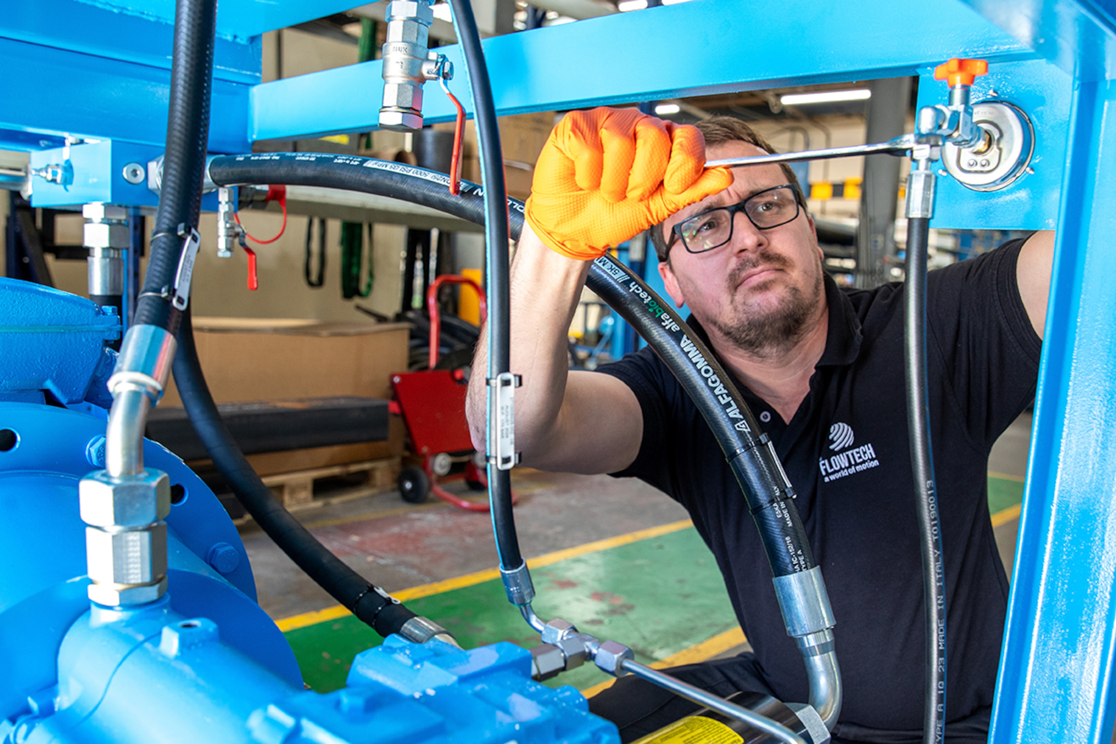 Flowtech engineer servicing blue hydraulic power pack